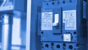 Un disjoncteur industriel dans un panneau électrique, son levier unique entre les repères ON et OFF.