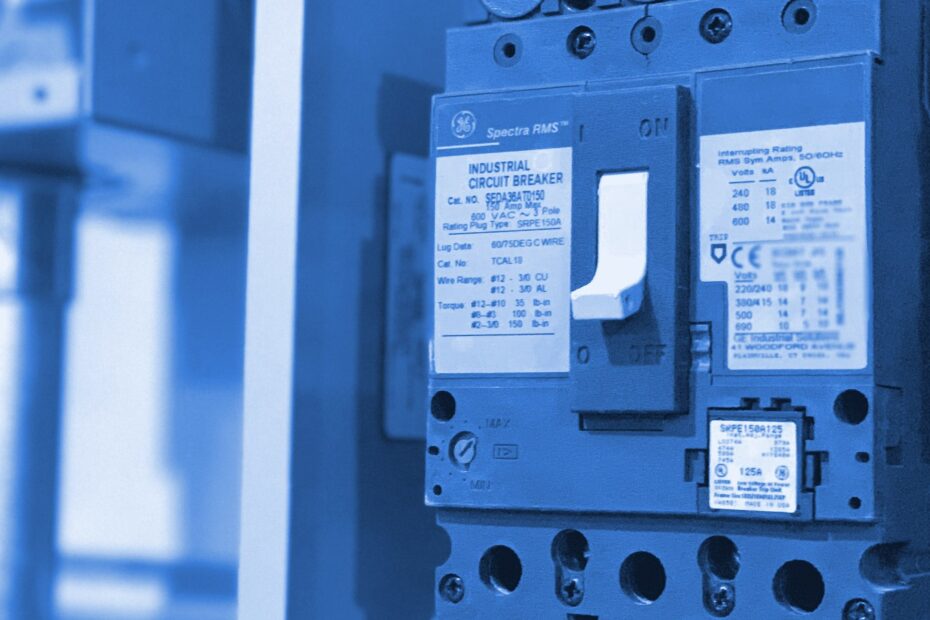Un disjoncteur industriel dans un panneau électrique, son levier unique entre les repères ON et OFF.